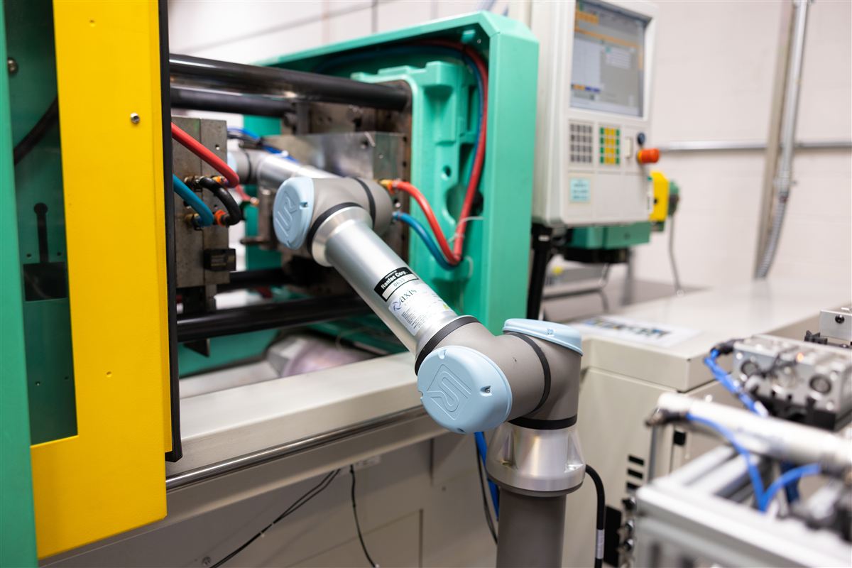 Robotic arm at automated injection molding cell